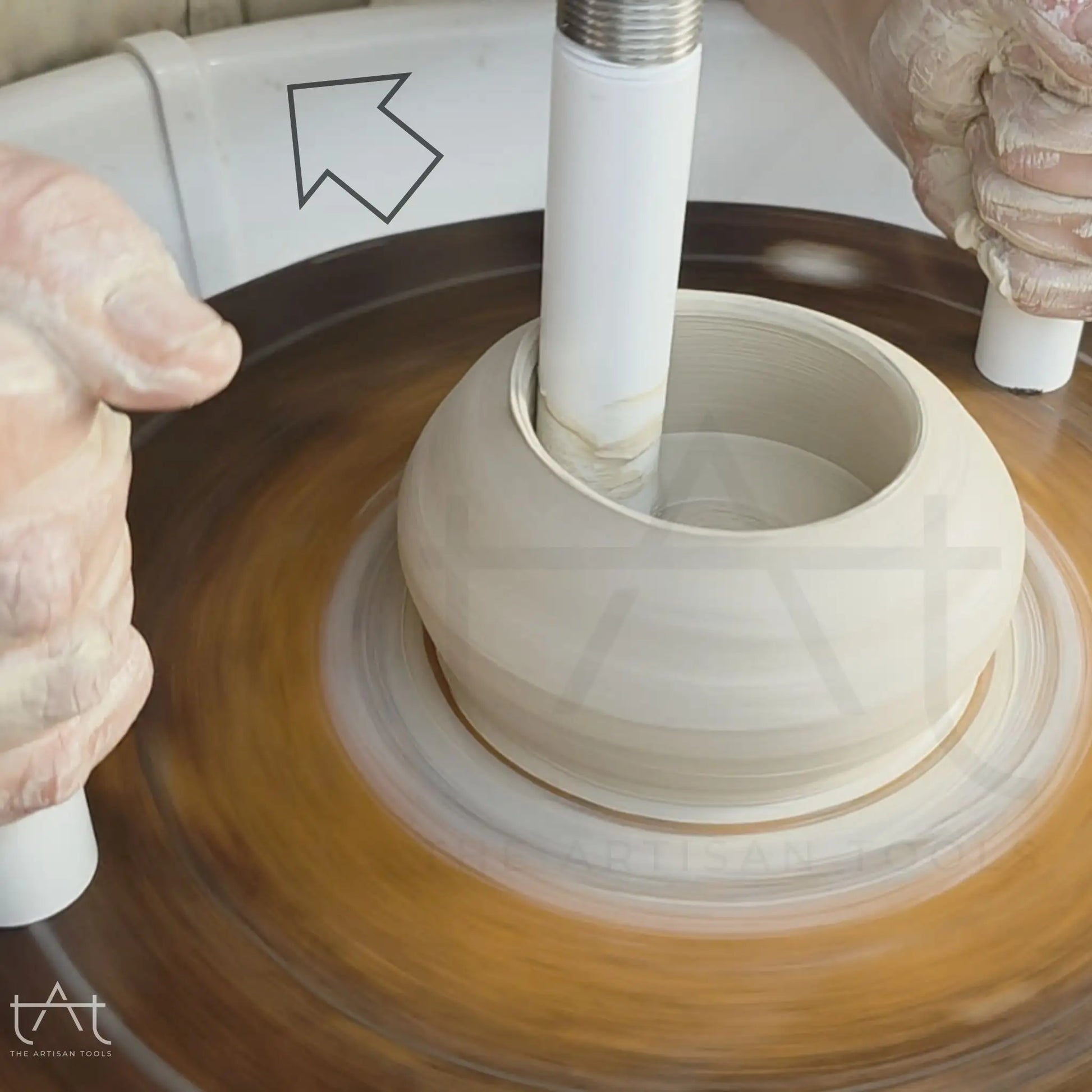 herramienta abriendo la pieza de barro con el grosor de la base definida en el torno alfarero