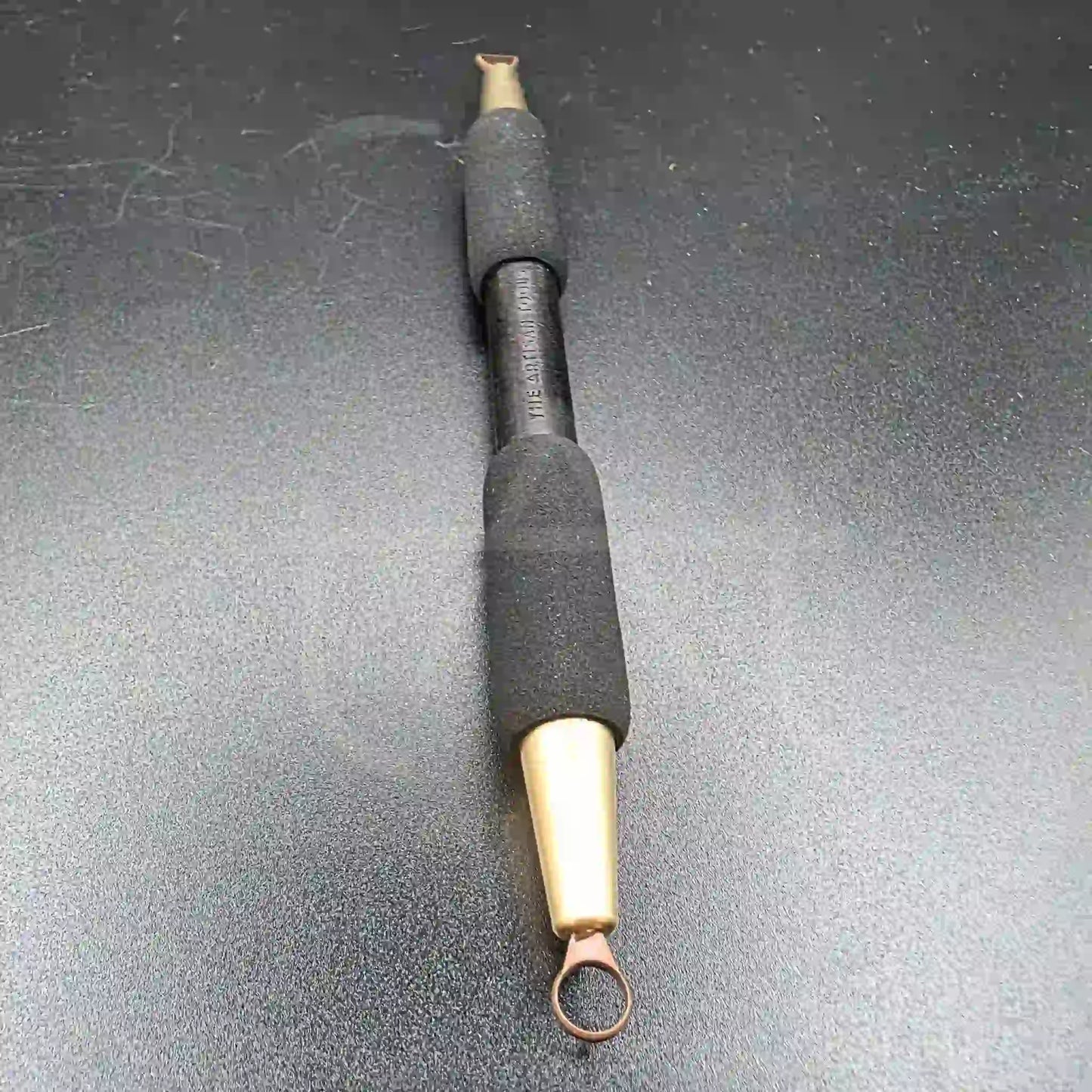 detalle del retorneador pequeño de doble punta con la punta redonda al frente y la plana al fondo 